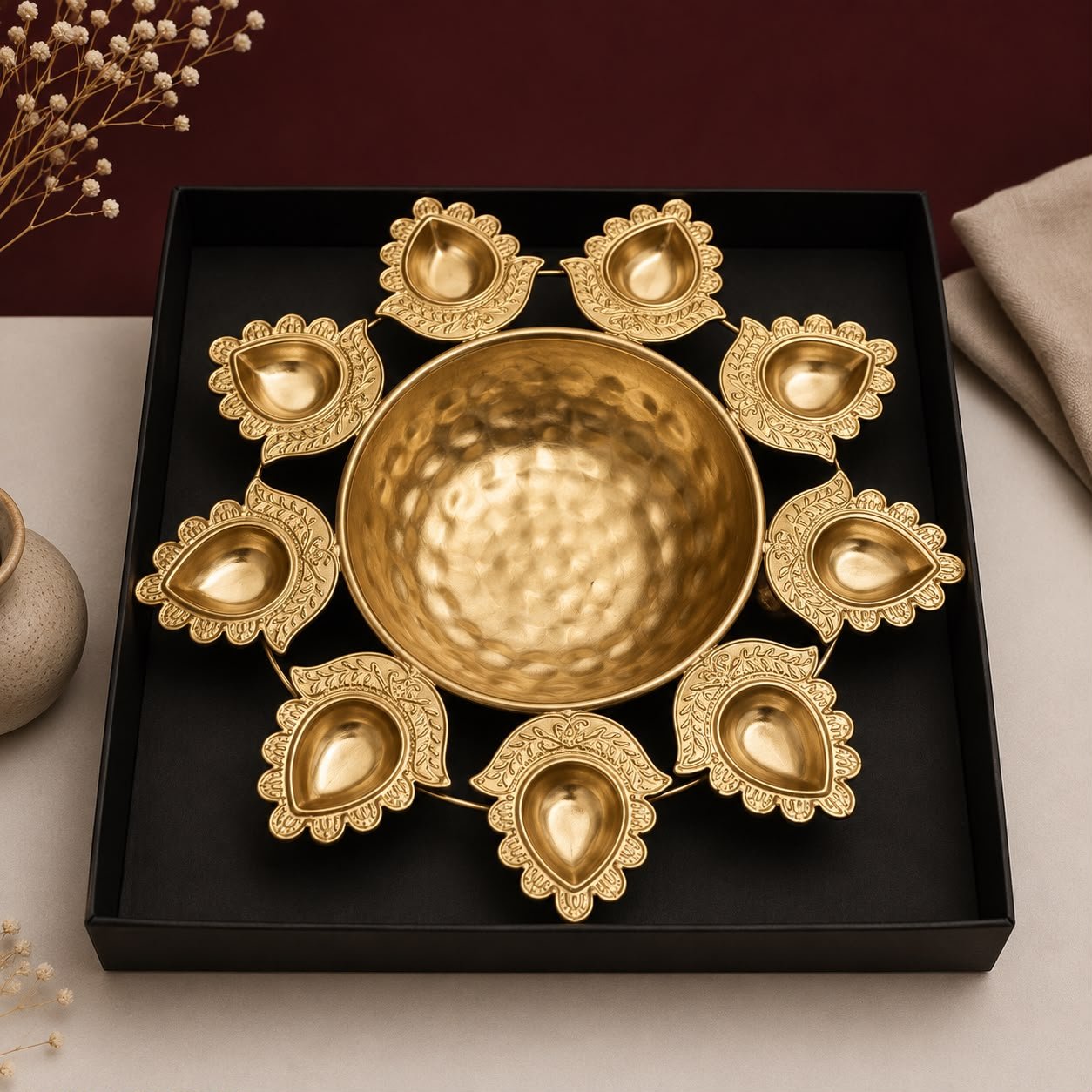 Handcrafted golden diya urli bowl with floating flowers and tea lights